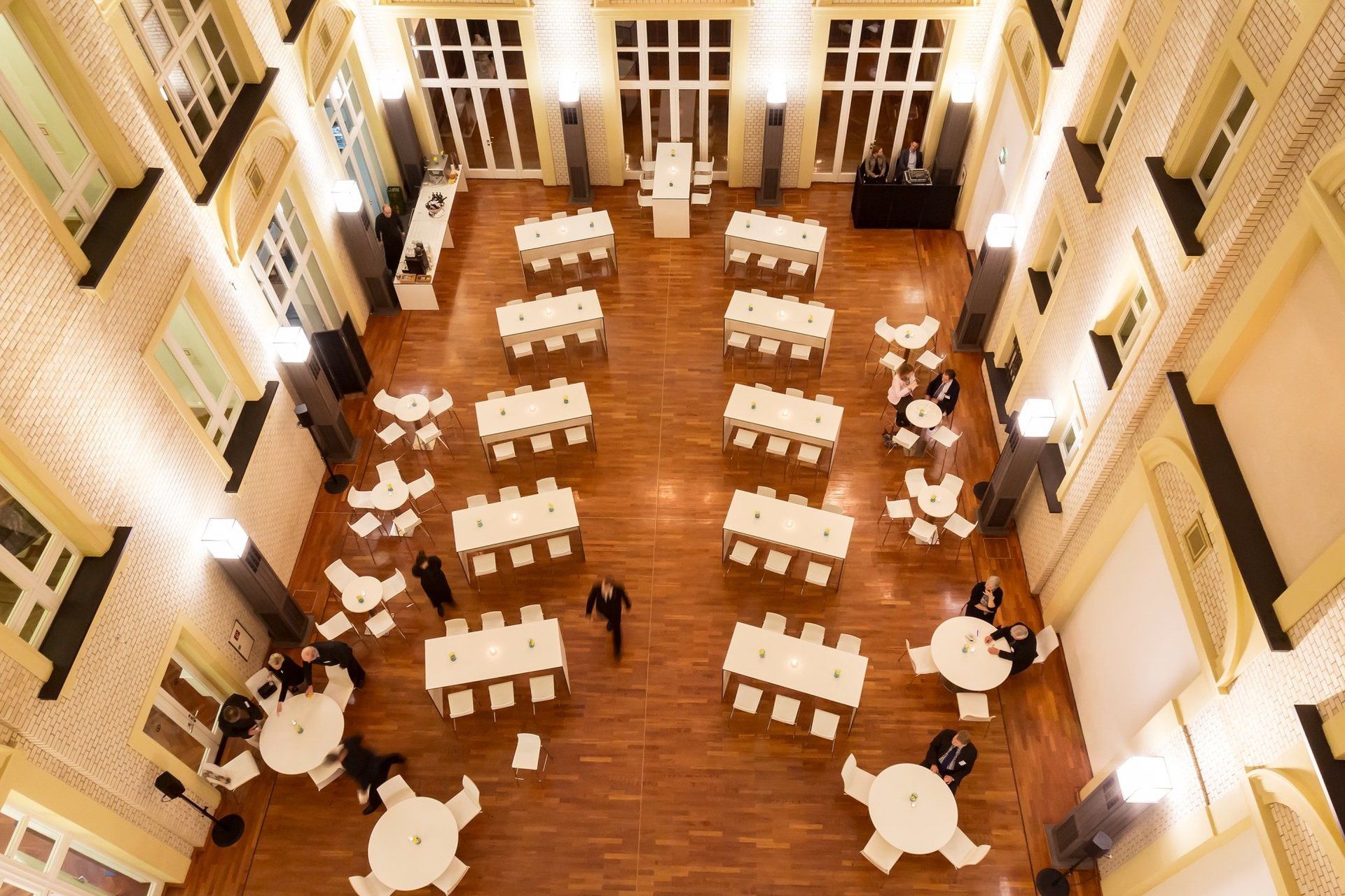 Blick von oben in den Lichthof des F.A.Z. Atriums. Arbeitsgruppentische in rund und rechteckig