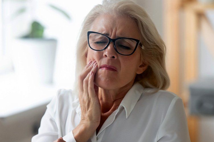 Elderly woman holding teeth