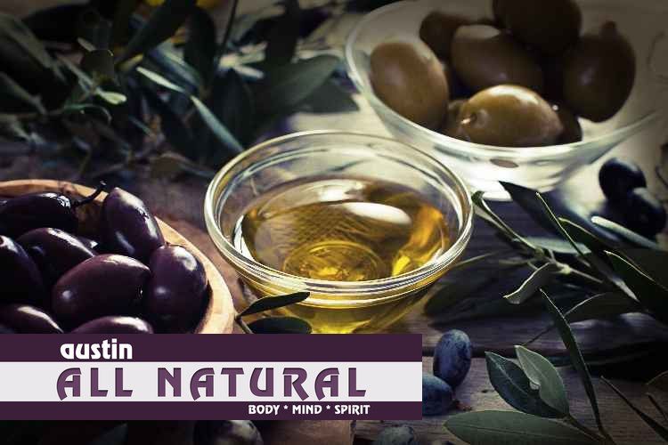A bowl of olives next to a bowl of olive oil