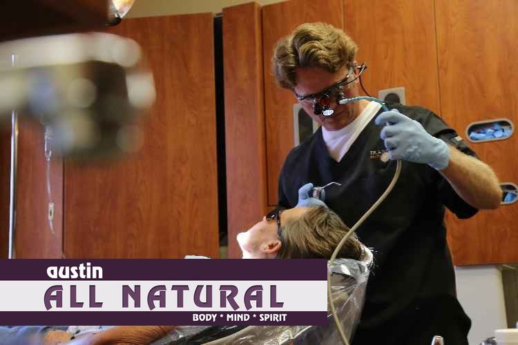 A man is getting his teeth examined by a dentist in austin all natural