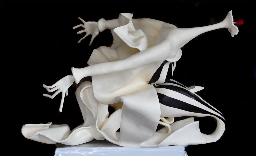Skulptur aus Pappmasché der Künstlerin Benita von Wendt.
Ansicht: Seite links.
Die abstrakte Skulptur erinnert an eine Frau die sich zum Kuss nach vorne beugt und sich gleichzeitig zurückzieht. Seitenansicht halbrechts.