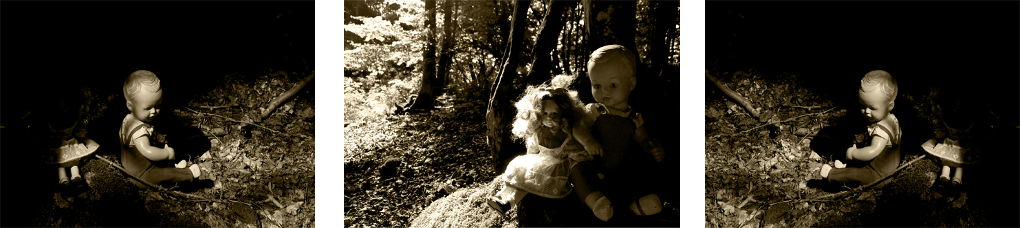 Fotografie der Künstlerin Benita von Wendt. Titel: Verletzlichkeit. Die Fotografie zeigt 3 identische männliche und 3 identische weibliche altmodische Puppen die auf dem Waldboden sitzen, ein Spiel aus Licht und Schatten setzt die Puppen in Szene, die Umgebung löst sich in der Dunkelheit auf. Die Fotoarbeit besteht aus 3 in sepiatönen gehaltenen Fotografien die miteinander in Beziehung stehen.