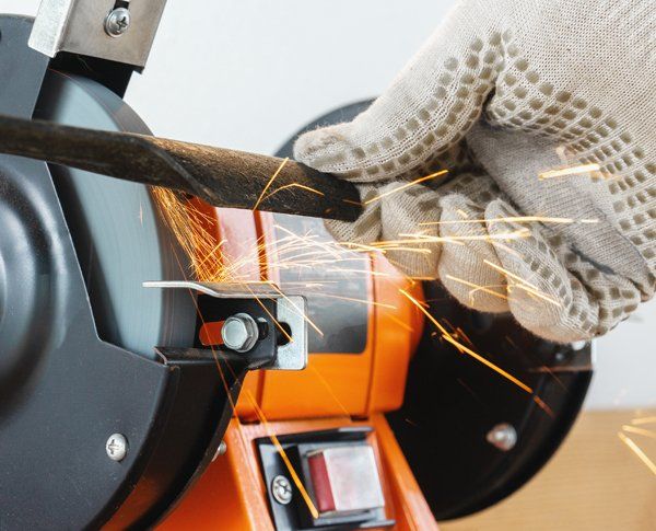 Professional worker sharpening a blade — Bartonville, IL — Bartonville Hardware Co.