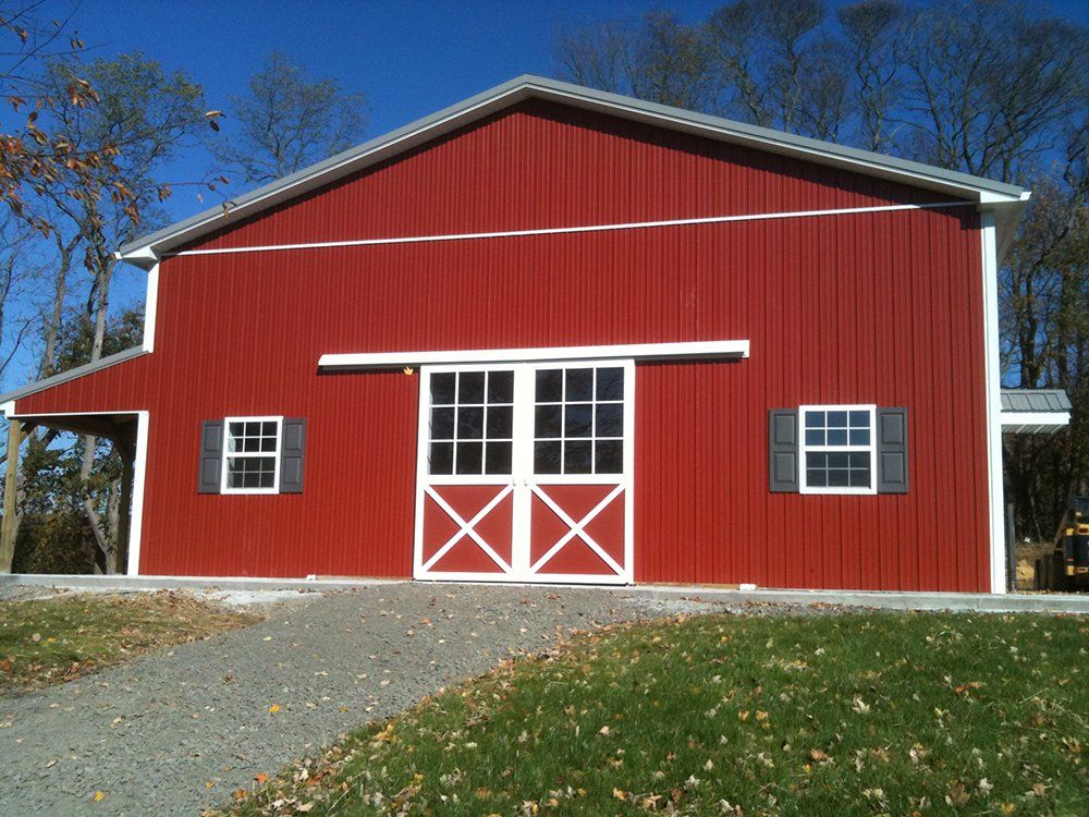 A red barn with white shutters and a sliding door