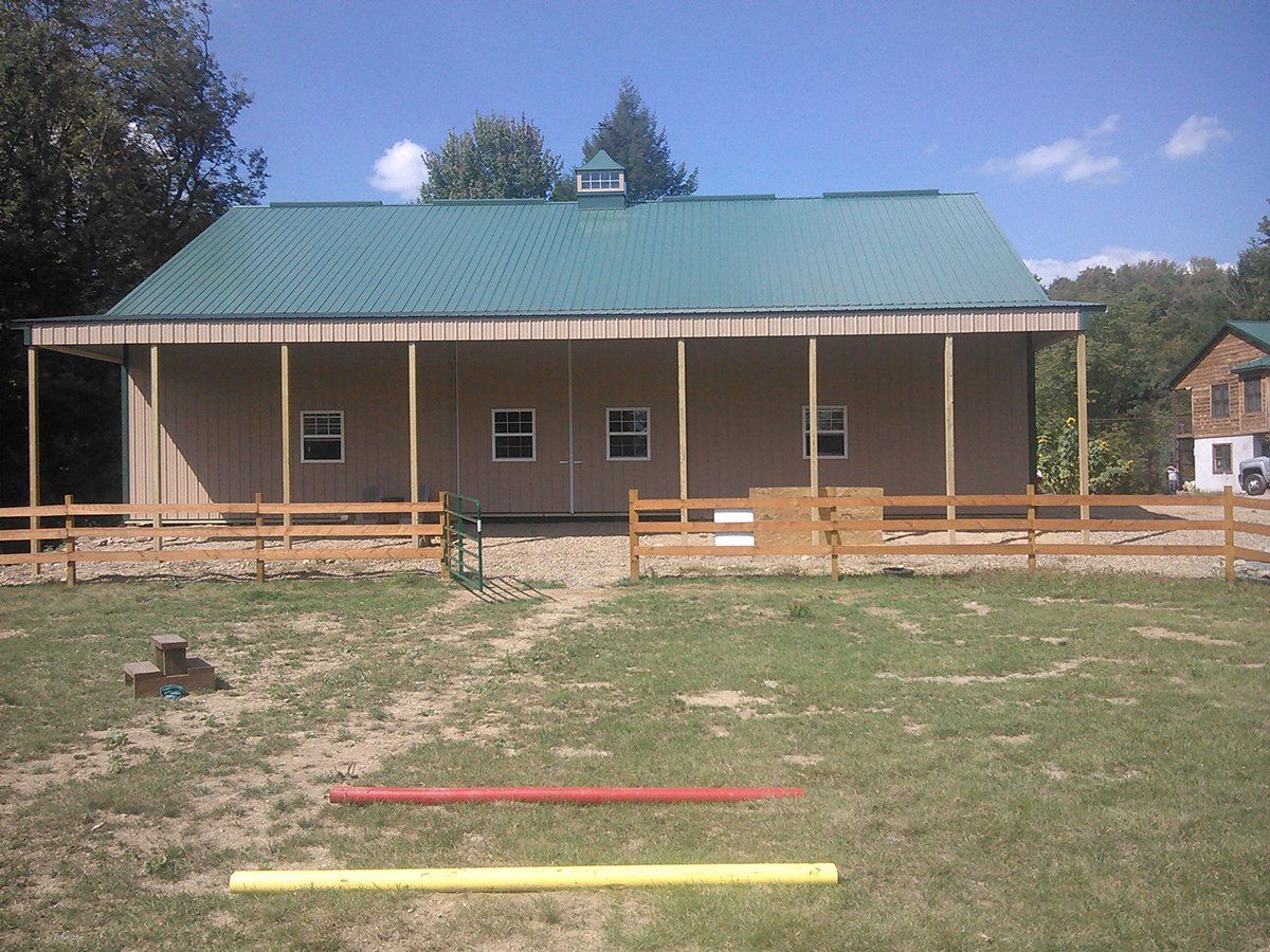 A house with a green roof and a wooden fence around it