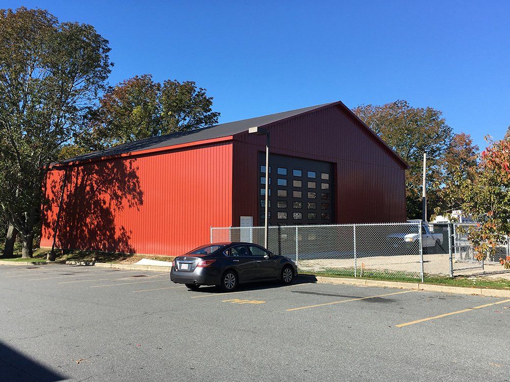 A car is parked in front of a large red building