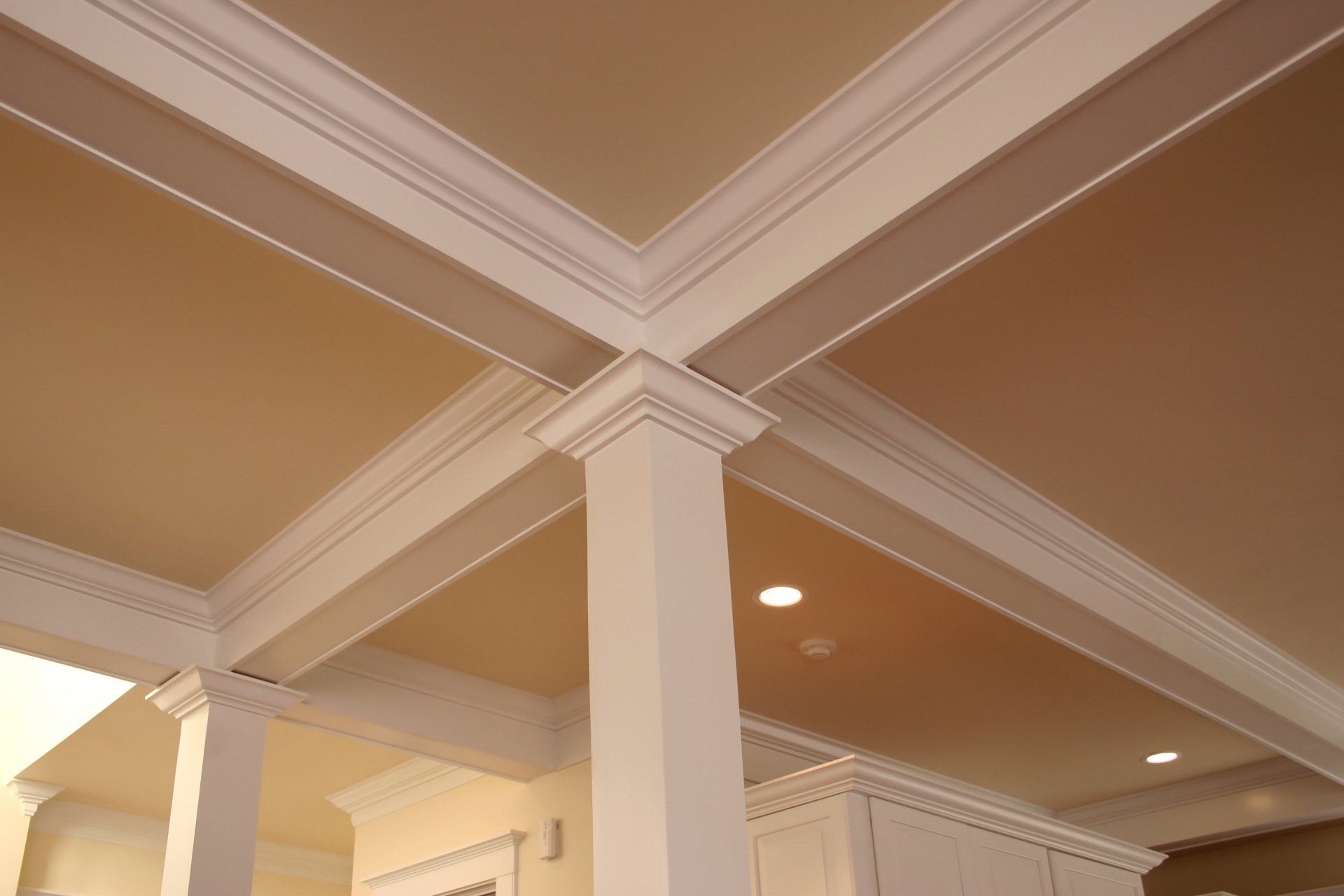 The ceiling of a room with columns and molding