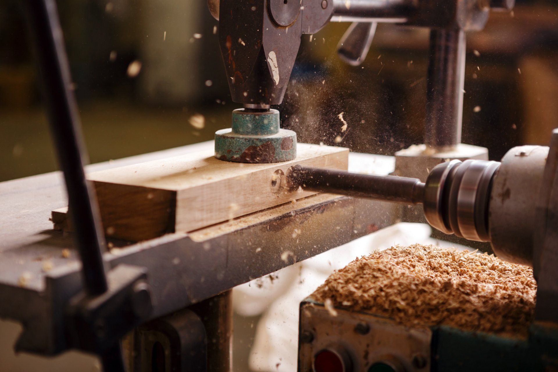 A drill is cutting a hole in a piece of wood.