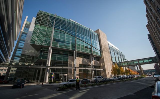A large building with a lot of windows is in the middle of a city.