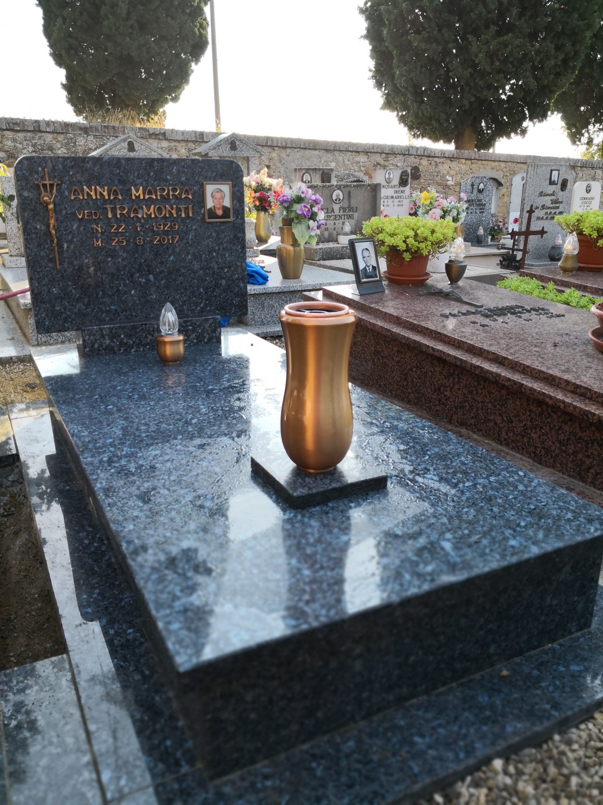 Una tomba con un vaso sopra in un cimitero