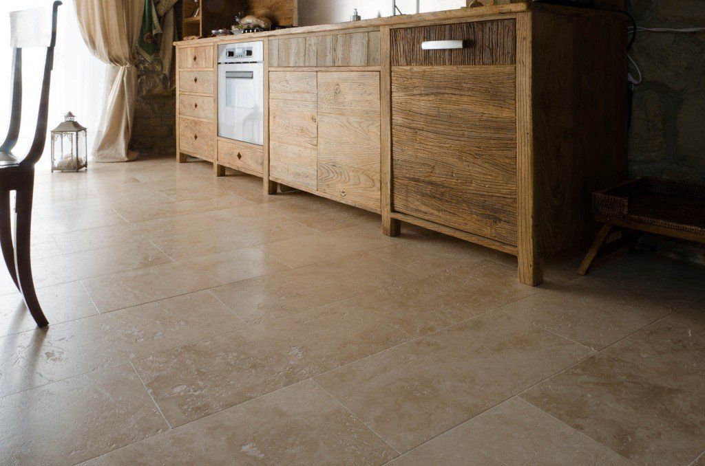 Una cucina con mobili in legno e pavimento piastrellato