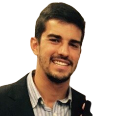 Um homem com barba está vestindo terno e sorrindo