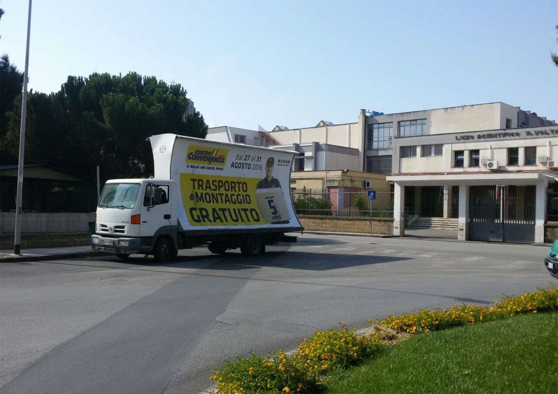 affissione pubblicitaria su camion a vela esterno giorno