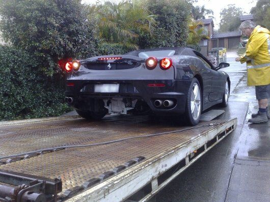 Tow Truck Loading Black Ferrari Car — Roadside Assistance in Berkley Vale, NSW