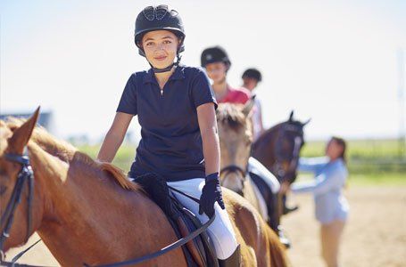 children sitting on the horses