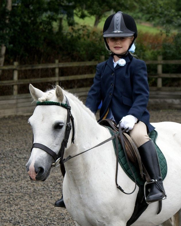 a young girl sitting on the horse