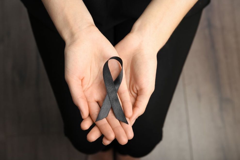 mani di donna con nastro nero in segno di lutto