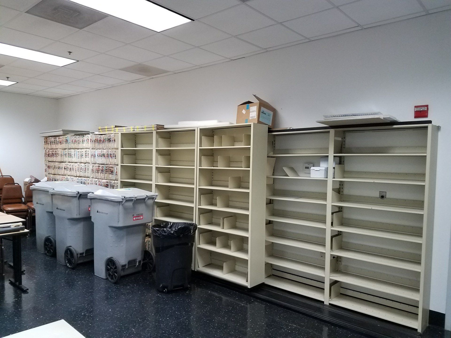 A room with a lot of shelves and trash cans
