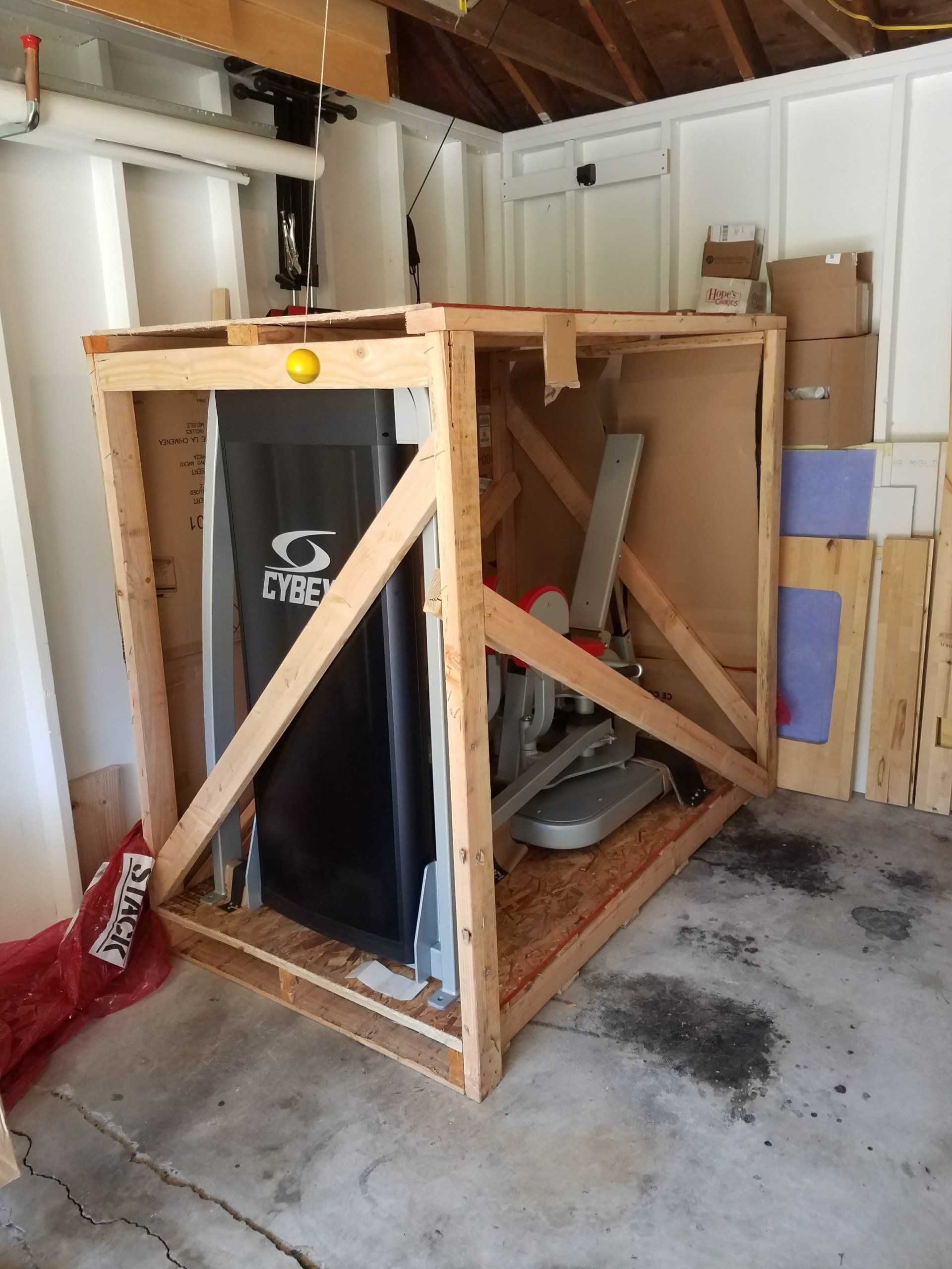 A treadmill is in a wooden box in a garage