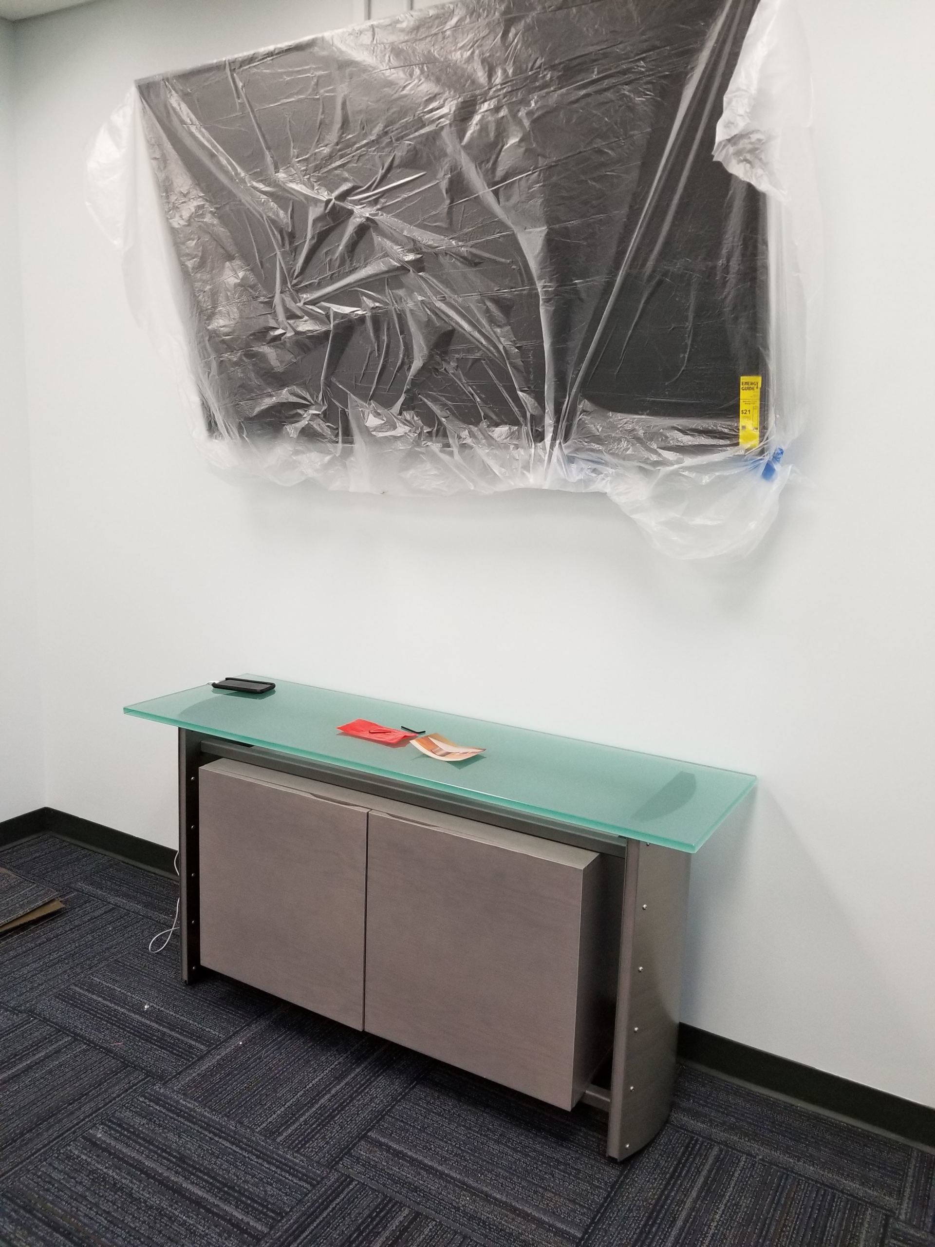 A room with a glass table and a picture on the wall.
