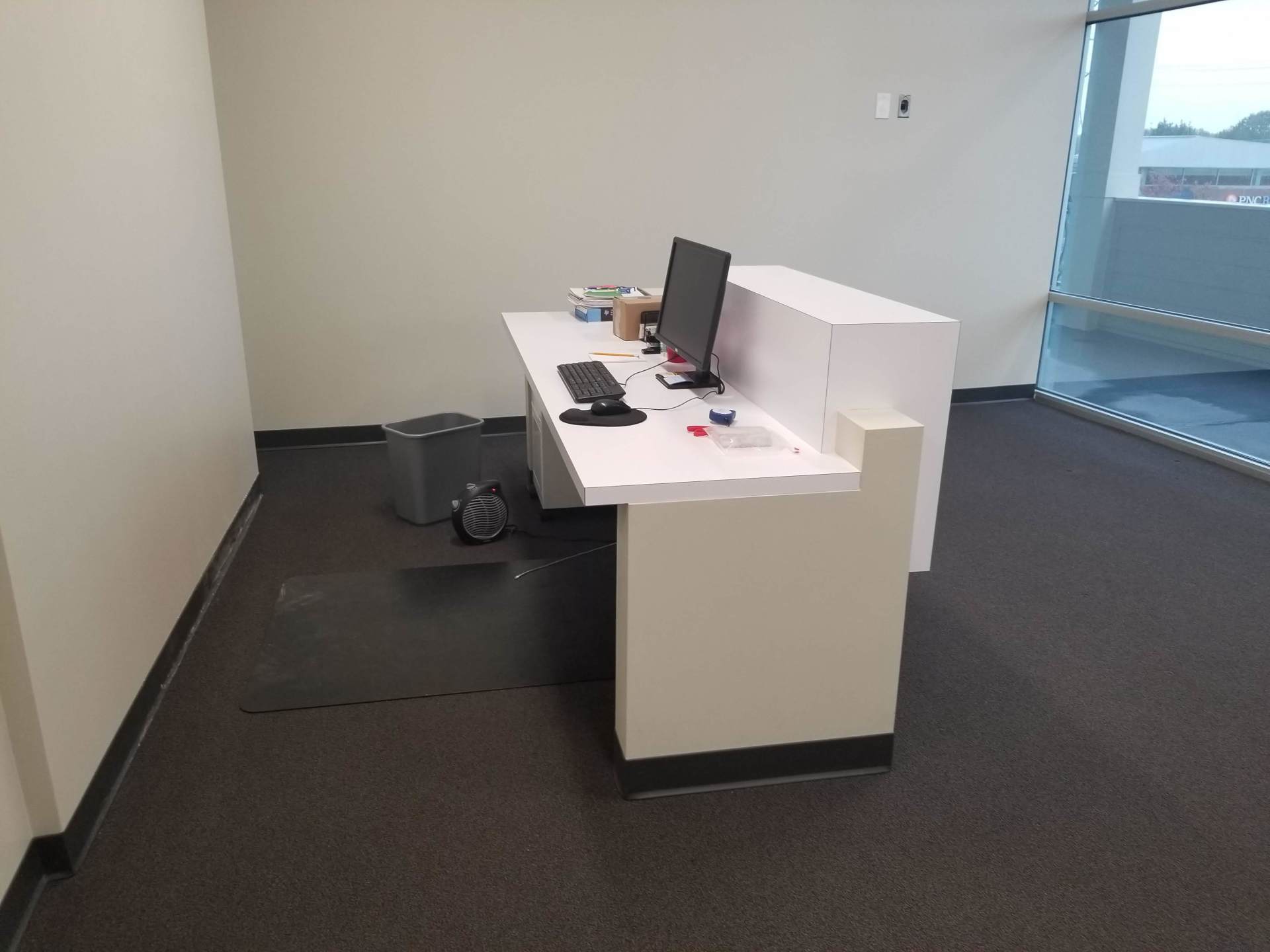 A white desk with a computer on it in a room.
