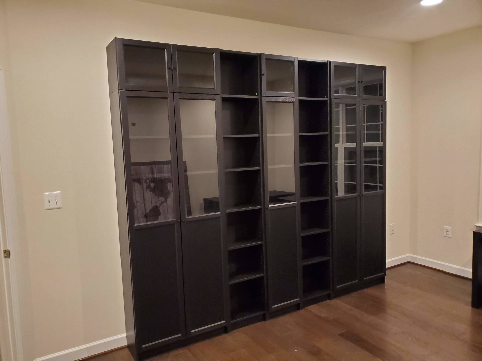 A room with a lot of shelves and glass doors.
