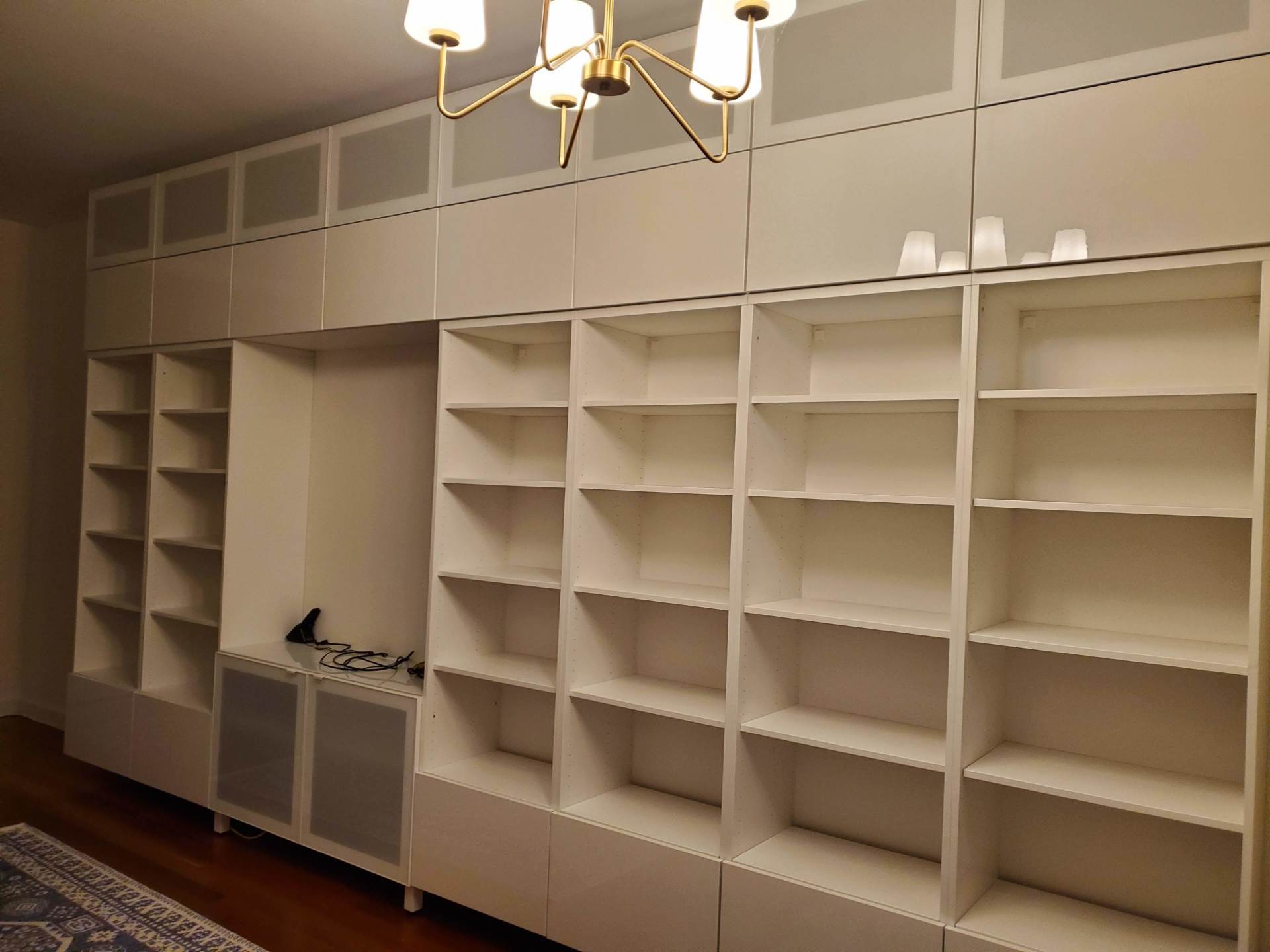 A room with a lot of shelves and a chandelier.