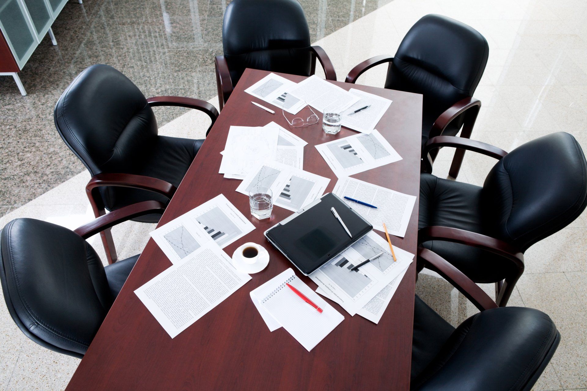 A conference table with a lot of papers on it
