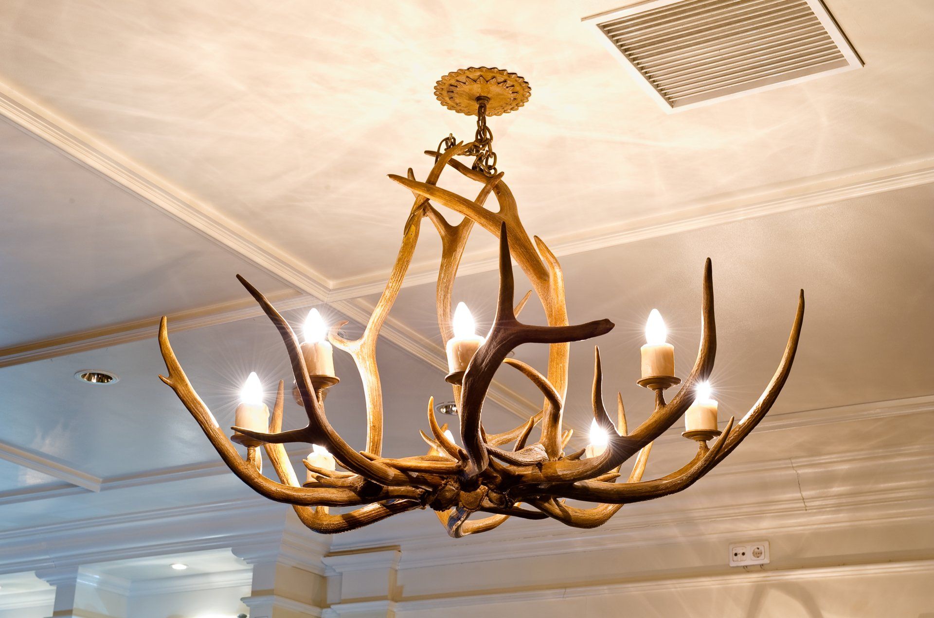 A chandelier made of antlers is hanging from the ceiling