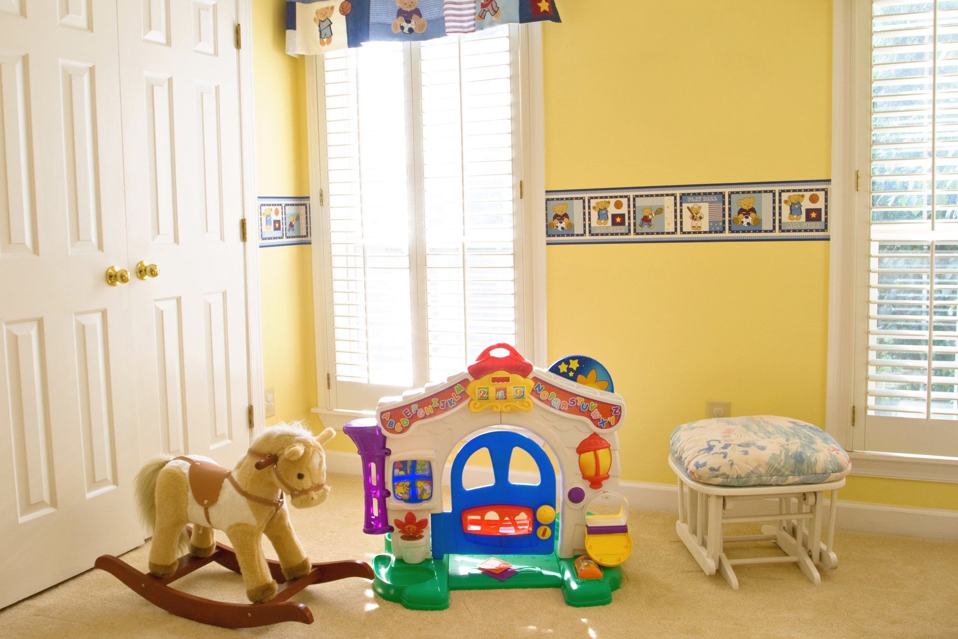 A room with a rocking horse and a toy house