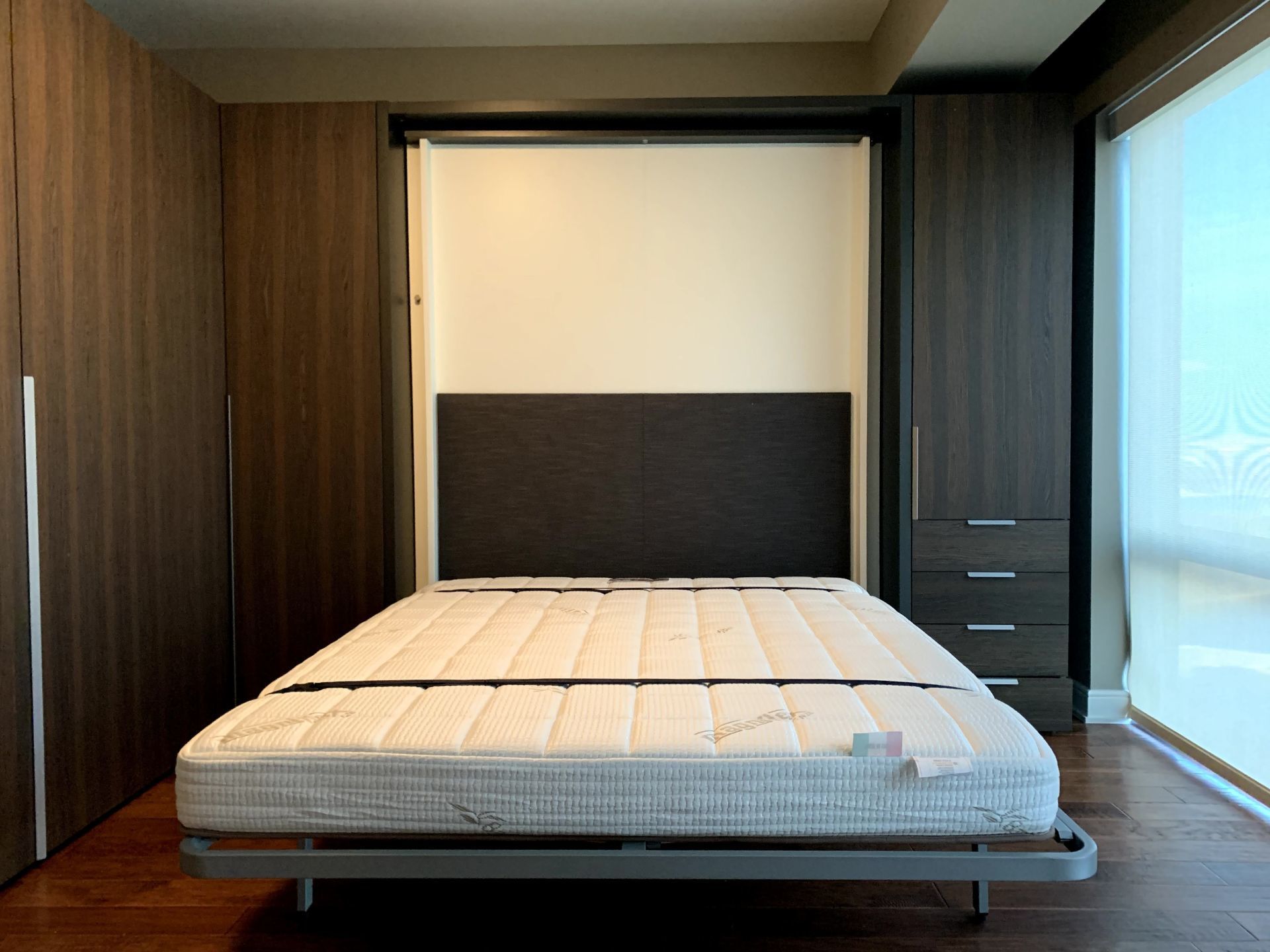 A bed with a white mattress and a black headboard