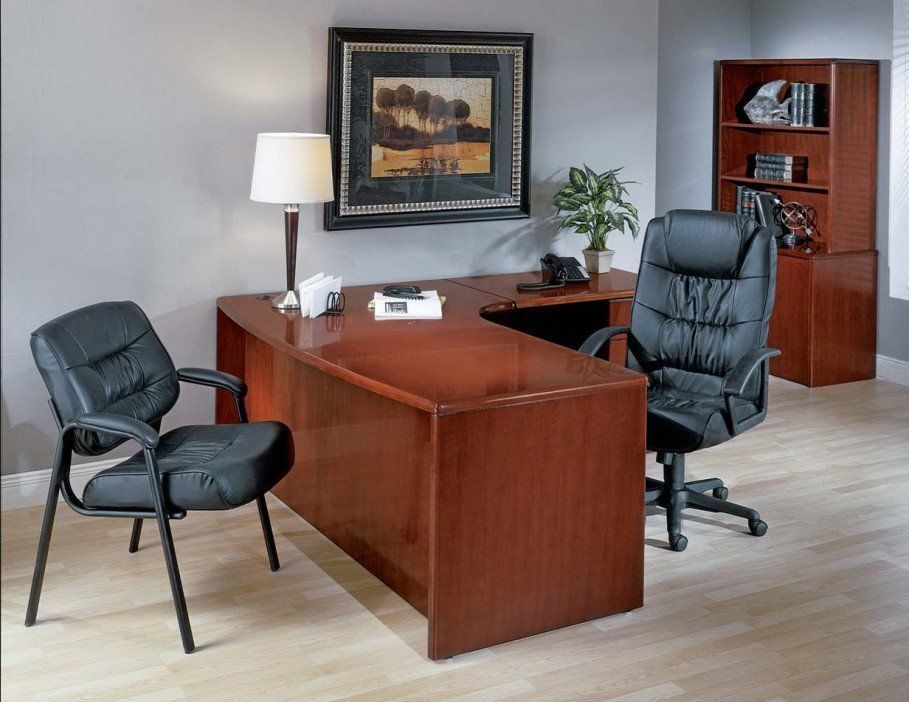 A room with a desk and chairs and a picture on the wall