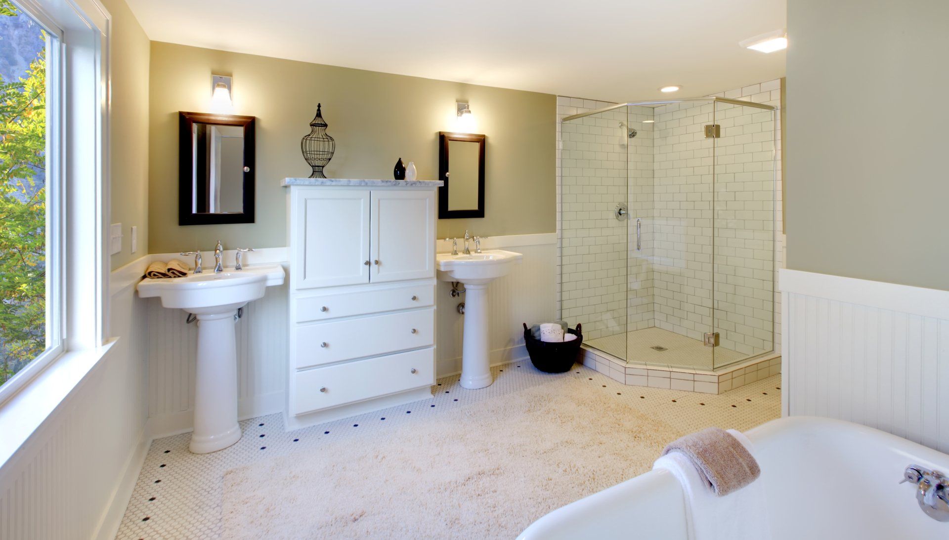 A bathroom with two sinks , a tub , and a walk in shower.