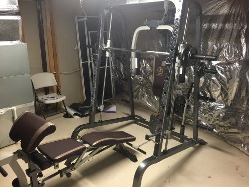 A gym with a bench and a squat rack