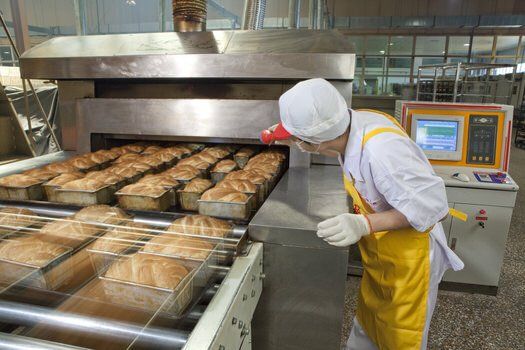 Man checking on bread in a food factory in Mississauga, Ontario.