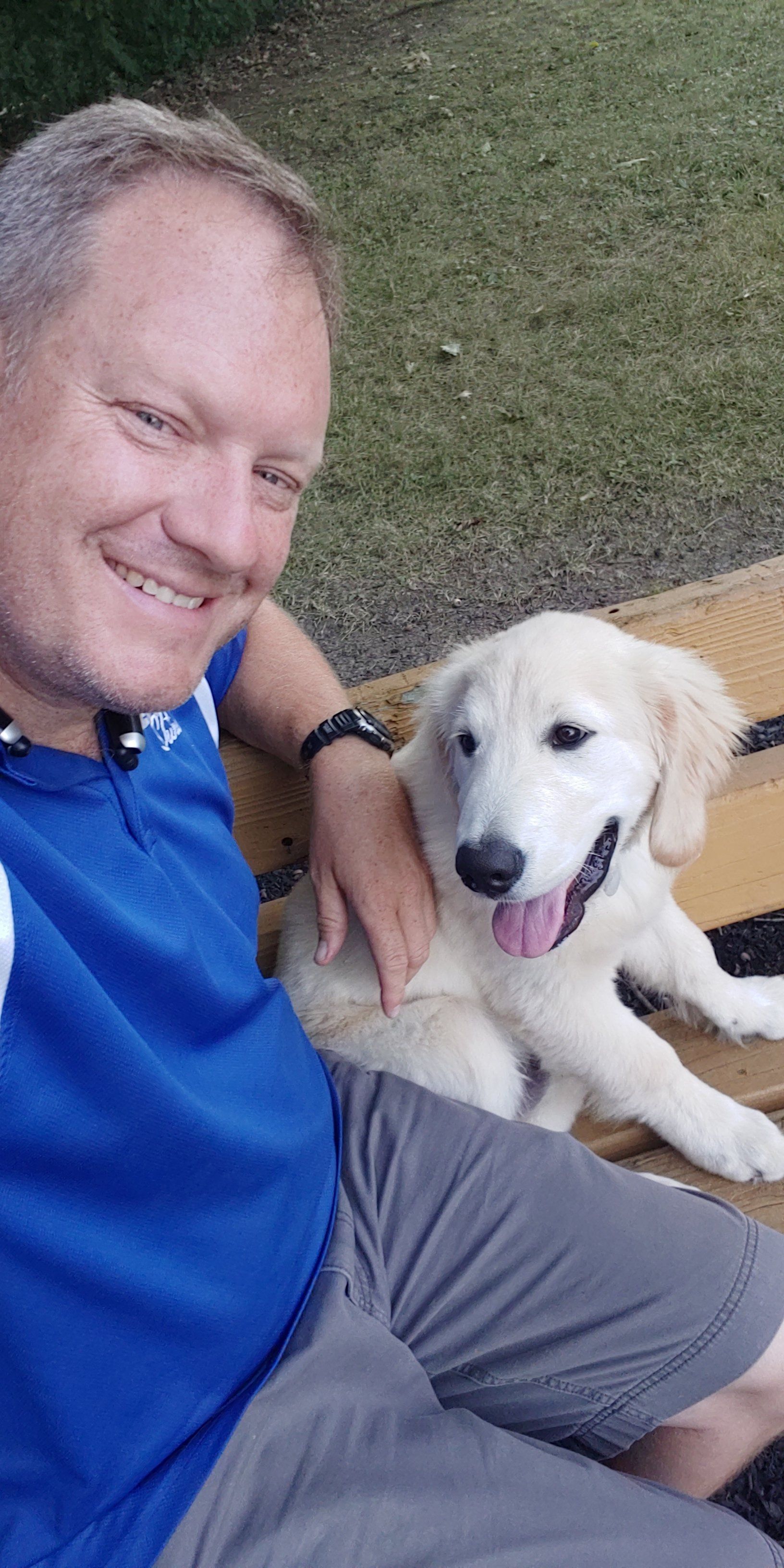 A man is sitting on a bench with a puppy