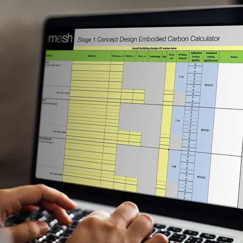 Hands typing on a laptop showing a carbon calculator spreadsheet on screen