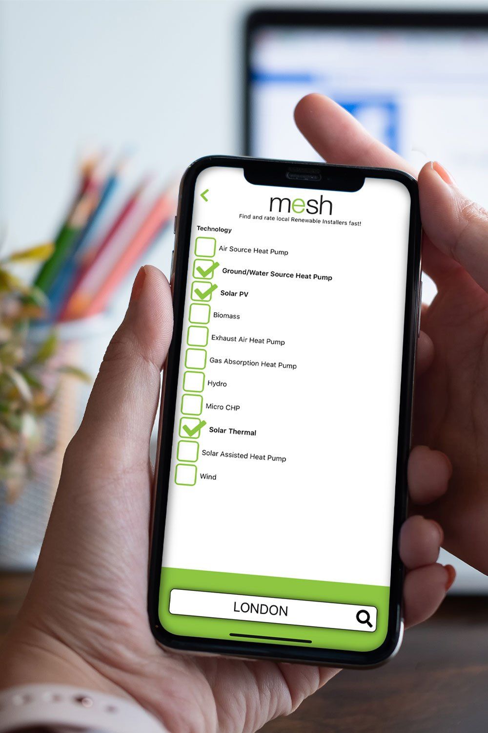 Hand holding a smartphone with a green checklist app on screen