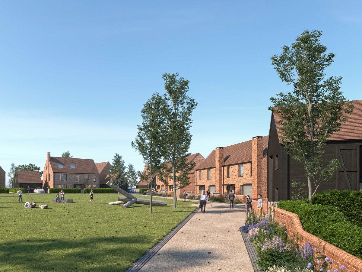 Pathway through grassy courtyard by brick houses on a sunny day