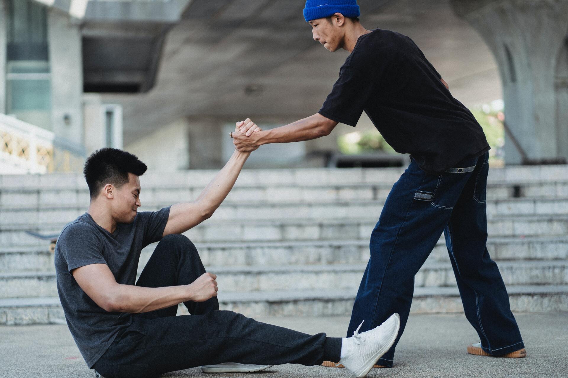 Man helping another man get up