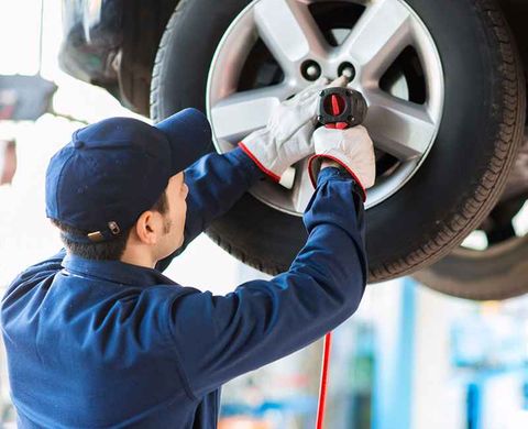 Mechanic fixing car tire - Tire Shop in Pomona, CA Mechanic fixing car tire - Tire Shop in Pomona, CA