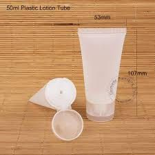 Un tubo de loción de plástico de 50 ml, con la tapa abierta al lado, sobre una estera de bambú.