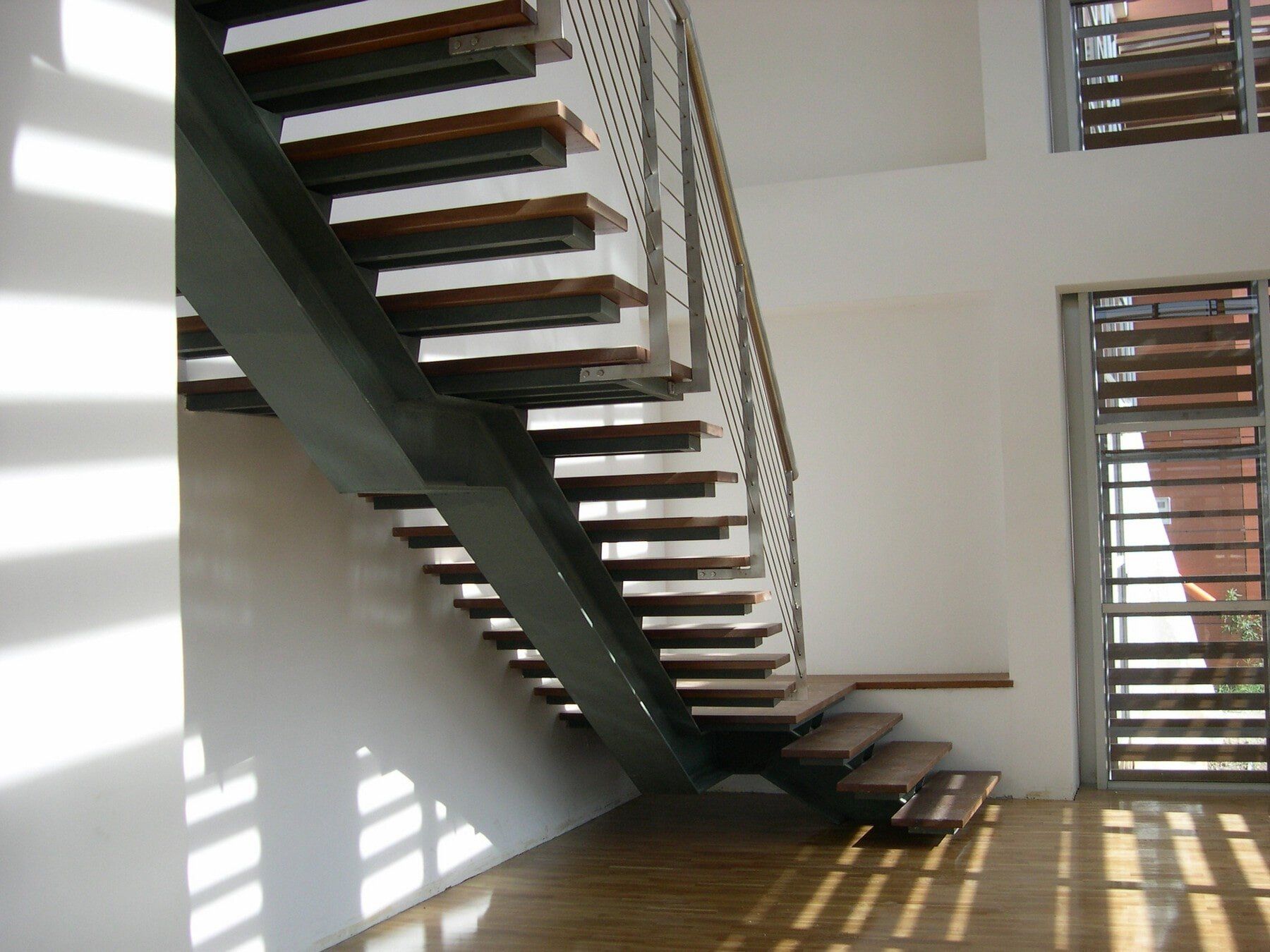 scala interna moderna con ringhiera in acciaio inox