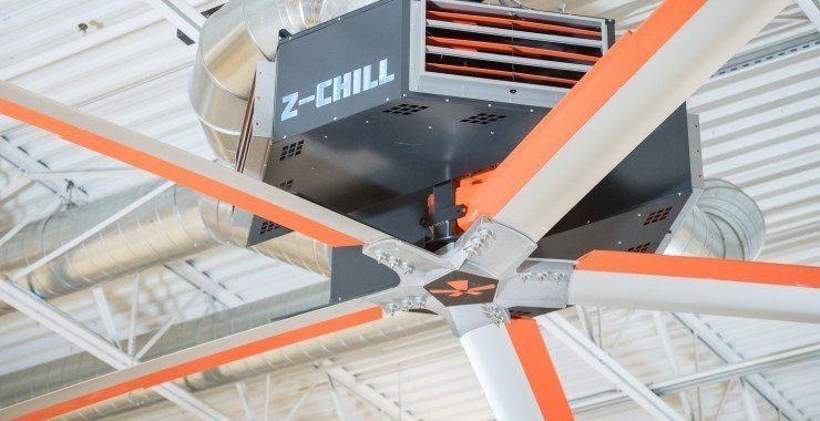 A large fan is hanging from the ceiling of a building.