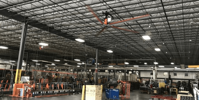 A large warehouse with a large fan hanging from the ceiling.