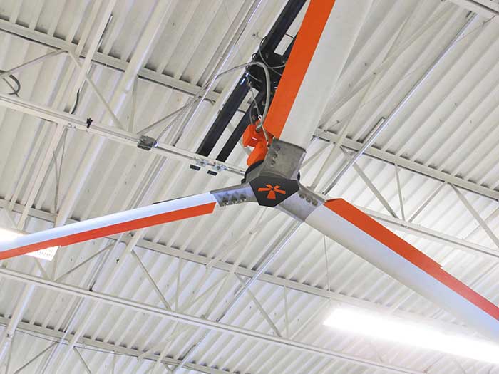 A large fan is hanging from the ceiling of a building.