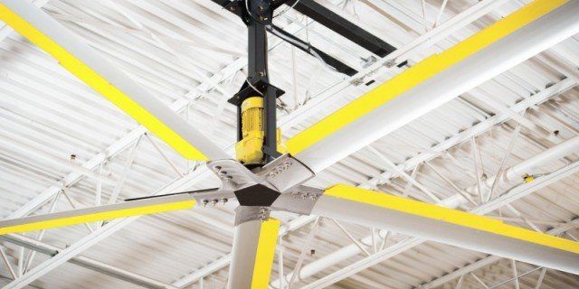 A large ceiling fan is hanging from the ceiling of a building.