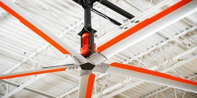 A large ceiling fan is hanging from the ceiling of a building.
