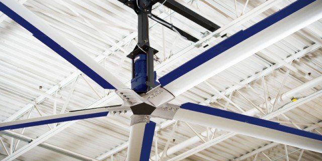 A large ceiling fan is hanging from the ceiling of a building.