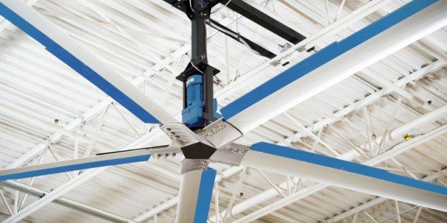 A large ceiling fan is hanging from the ceiling of a building.